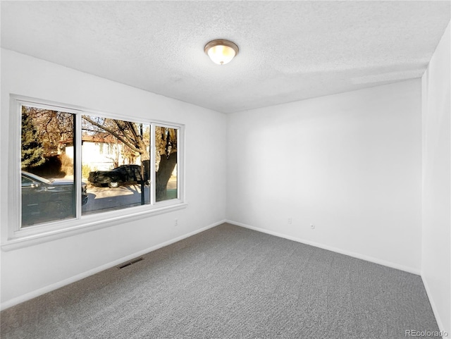 carpeted empty room with a textured ceiling