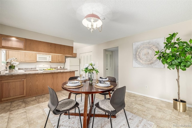 dining area featuring a textured ceiling and a chandelier