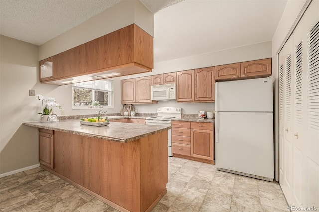 kitchen featuring sink, white appliances, kitchen peninsula, and a textured ceiling