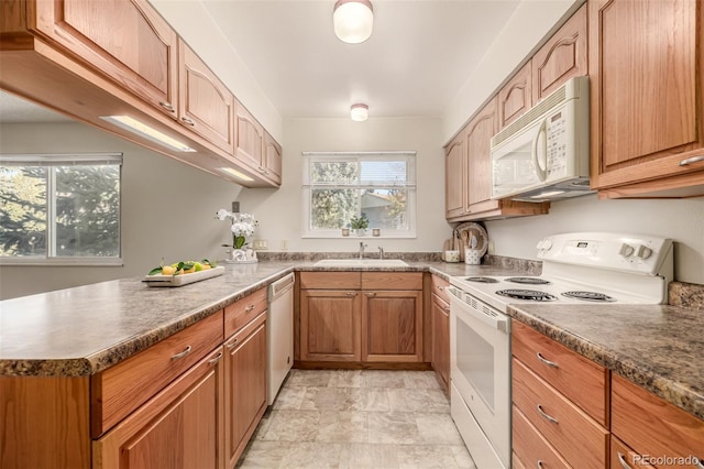 kitchen with sink, white appliances, kitchen peninsula, and a healthy amount of sunlight