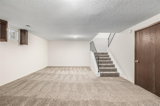 basement with light carpet and a textured ceiling