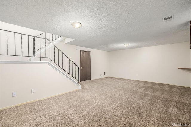 basement featuring carpet floors and a textured ceiling