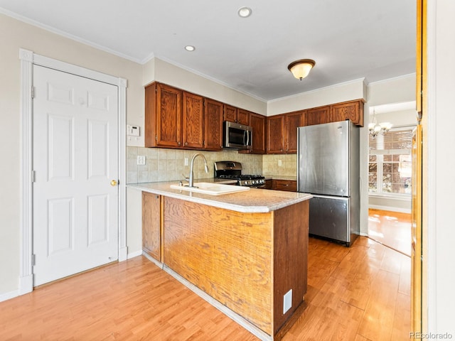 kitchen with stainless steel appliances, sink, decorative backsplash, and kitchen peninsula