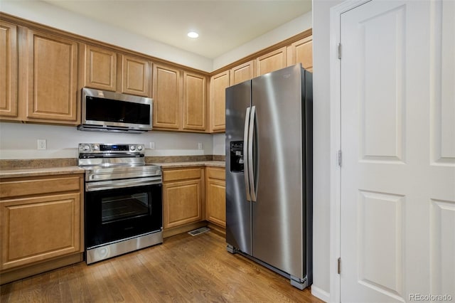 7046 Red Sand Grv, Colorado Springs, CO 80923 - kitchen featuring appliances with stainless steel finishes, dark wood-style floors, recessed lighting, brown cabinetry, and light countertops