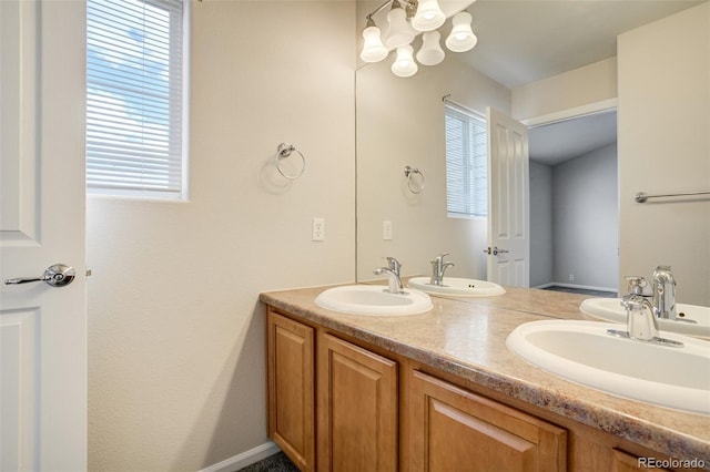7046 Red Sand Grv, Colorado Springs, CO 80923 - bathroom featuring double vanity and a chandelier