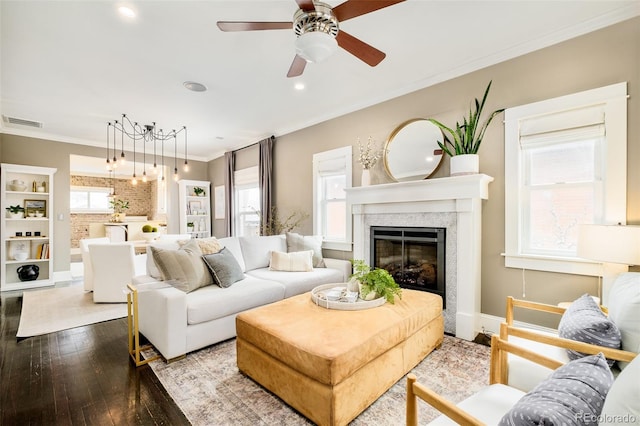 living area with plenty of natural light, visible vents, and ornamental molding