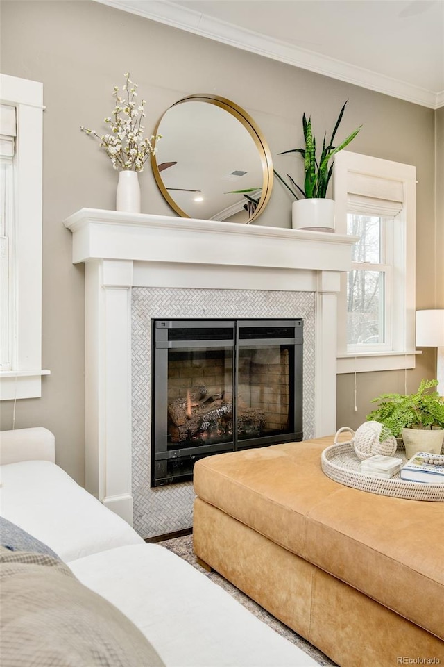 interior details featuring a tile fireplace and crown molding