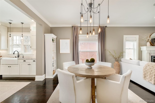 dining space with dark wood-style flooring, visible vents, crown molding, and a premium fireplace