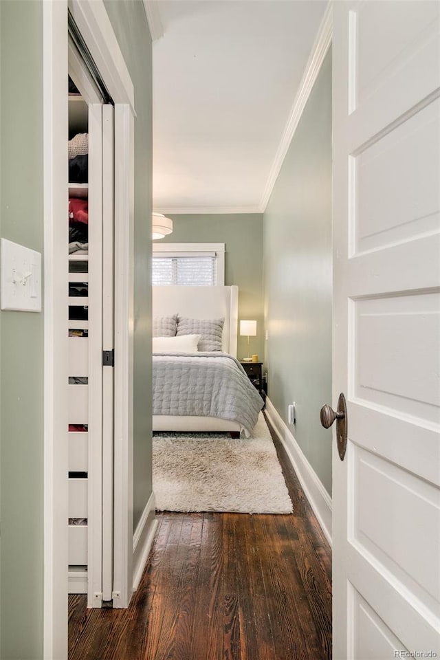 unfurnished bedroom featuring dark wood-style floors, baseboards, and ornamental molding