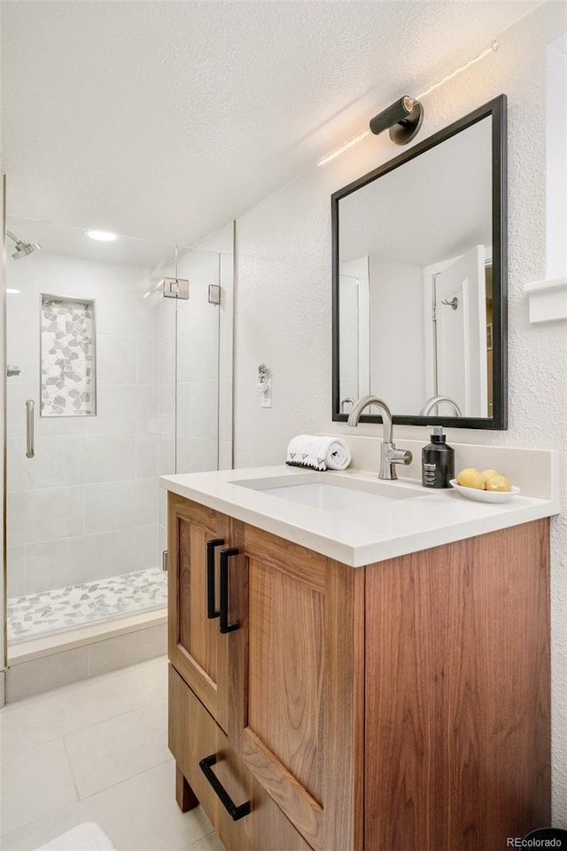 bathroom with a textured ceiling, a shower stall, vanity, and tile patterned floors