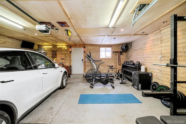 exercise room with a garage and wooden walls