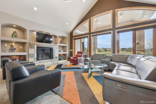 living room with built in features, a fireplace, and high vaulted ceiling