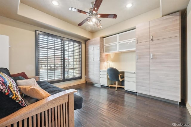 interior space with built in desk, dark hardwood / wood-style floors, and ceiling fan