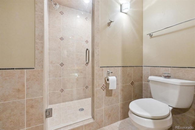 bathroom with toilet, tile walls, and a shower with shower door