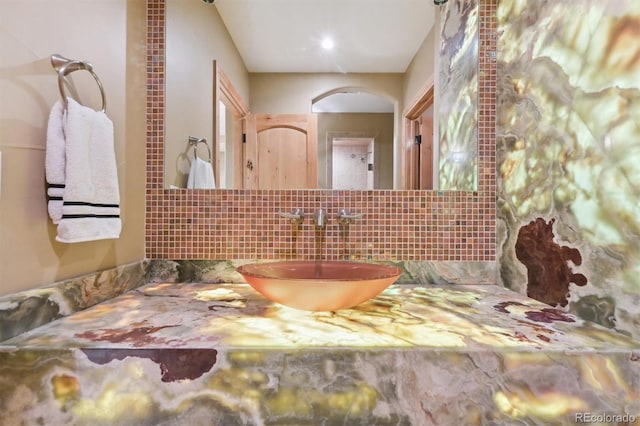 bathroom featuring vanity and tasteful backsplash