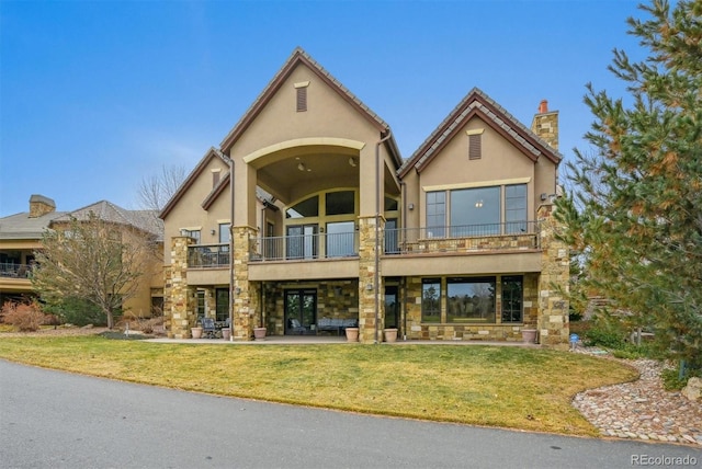 view of front of house featuring a patio area, a balcony, and a front yard