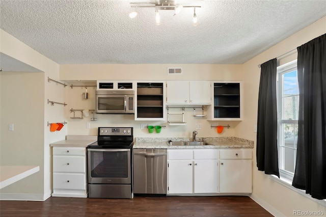 kitchen with white cabinetry, sink, appliances with stainless steel finishes, a textured ceiling, and dark hardwood / wood-style flooring