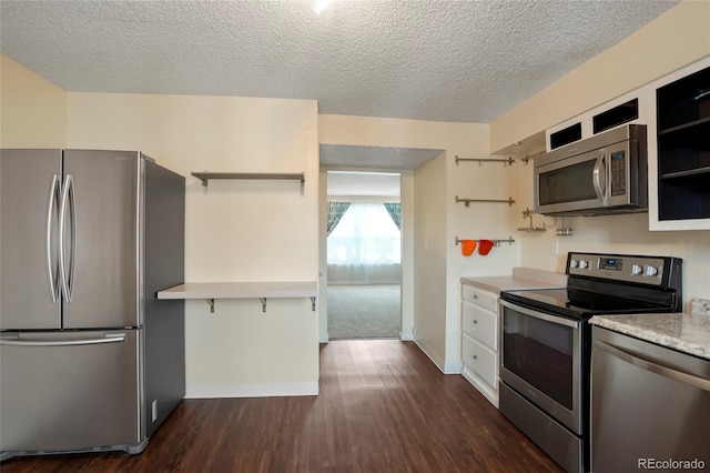 kitchen featuring a textured ceiling, dark hardwood / wood-style floors, and stainless steel appliances