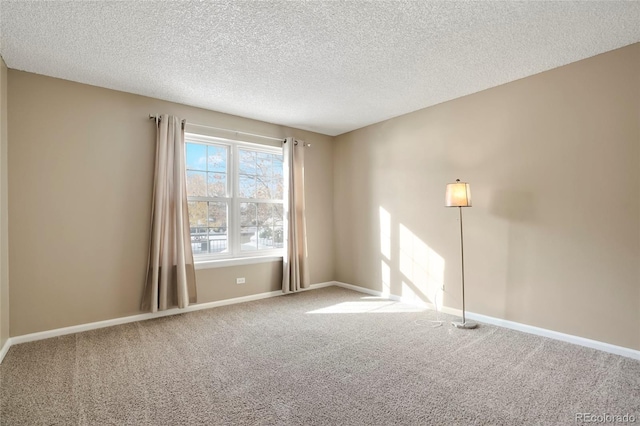 carpeted empty room with a textured ceiling