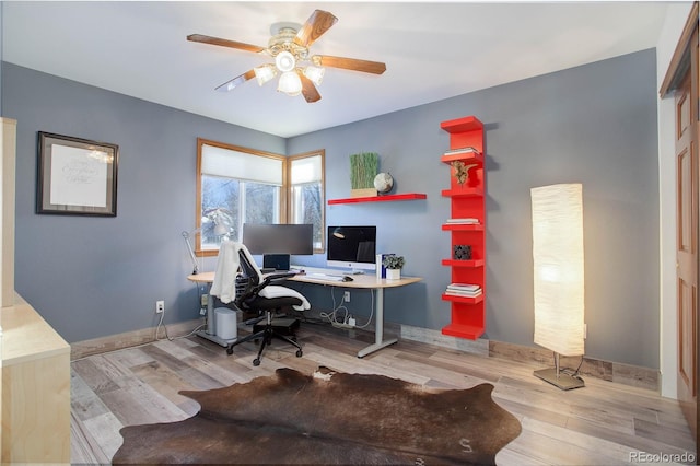 home office with light wood-type flooring and ceiling fan