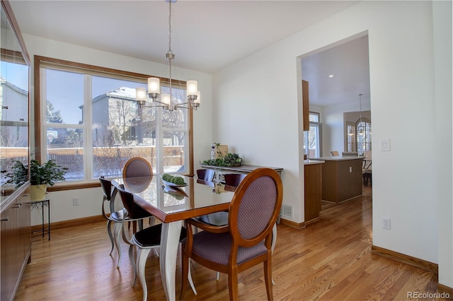 dining room featuring light hardwood / wood-style flooring and a chandelier