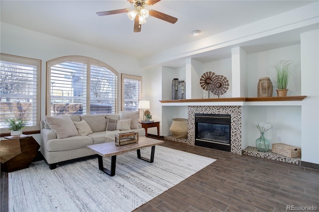 living room featuring a tile fireplace, a wealth of natural light, and ceiling fan