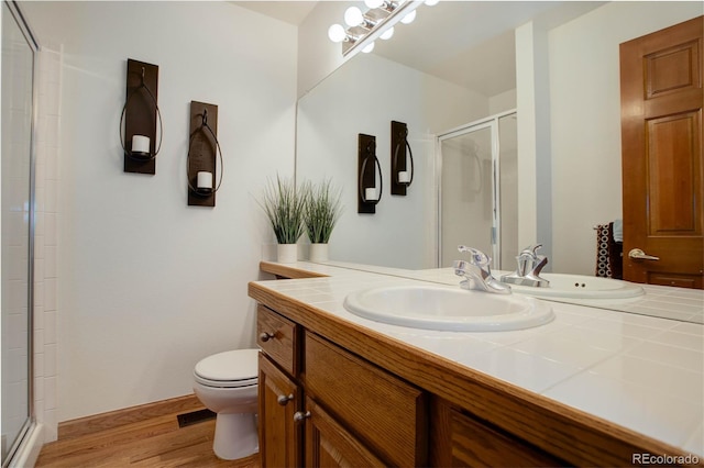 bathroom featuring vanity, toilet, wood-type flooring, and walk in shower