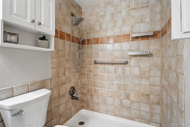11625 Bellaire Way, Thornton, CO 80233 - bathroom featuring tiled shower, toilet, and tile walls