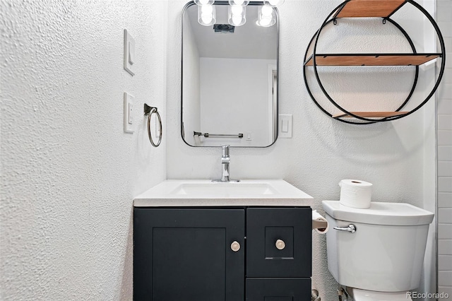 11625 Bellaire Way, Thornton, CO 80233 - bathroom with vanity, a textured wall, and toilet