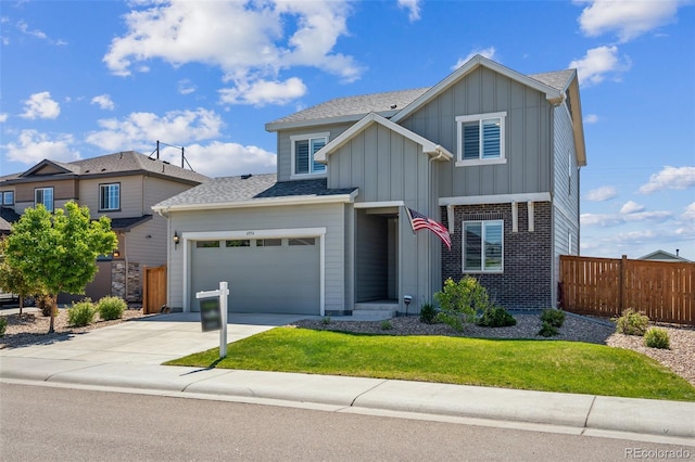 6954 E 117th Ave, Thornton, CO 80233 - view of front facade with board and batten siding, driveway, brick siding, roof with shingles, and a garage