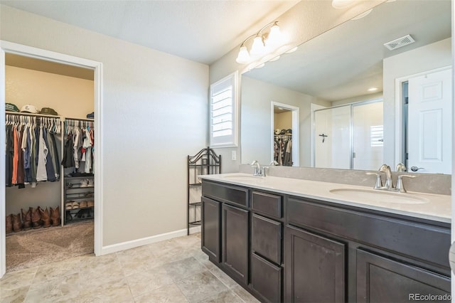 6954 E 117th Ave, Thornton, CO 80233 - bathroom featuring a walk in closet, double vanity, a stall shower, and baseboards