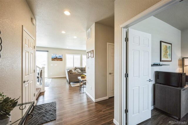 6954 E 117th Ave, Thornton, CO 80233 - corridor featuring dark wood-style flooring, baseboards, recessed lighting, a textured ceiling, and a textured wall