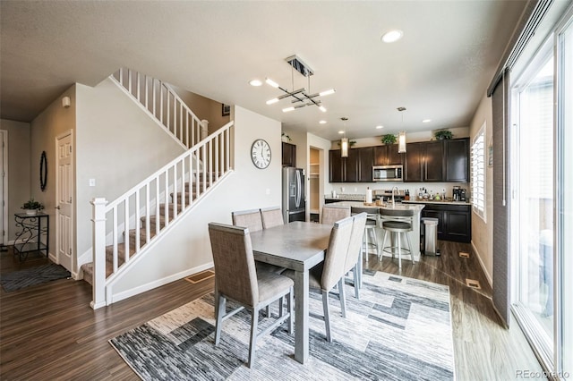 6954 E 117th Ave, Thornton, CO 80233 - dining space featuring baseboards, stairway, wood finished floors, and recessed lighting