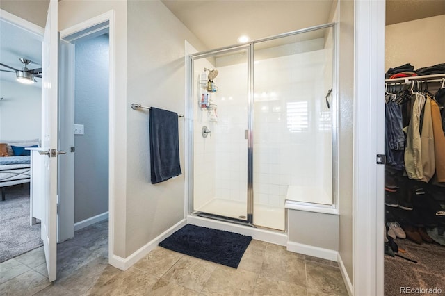 6954 E 117th Ave, Thornton, CO 80233 - ensuite bathroom with a walk in closet, a stall shower, baseboards, and tile patterned floors