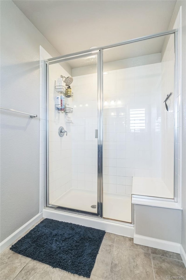 6954 E 117th Ave, Thornton, CO 80233 - bathroom featuring a shower stall, tile patterned floors, and baseboards