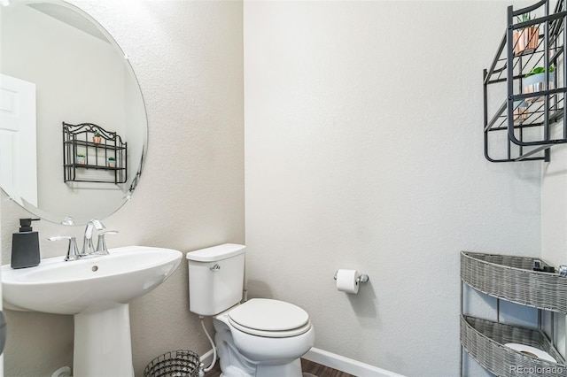 6954 E 117th Ave, Thornton, CO 80233 - bathroom featuring toilet, wood finished floors, a sink, and baseboards
