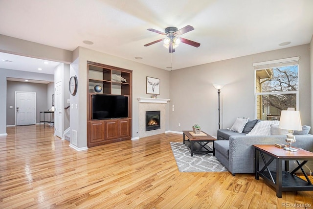 10247 Telluride Way, Commerce City, CO 80022 - living area featuring light wood finished floors, a ceiling fan, and a glass covered fireplace