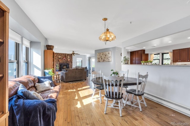 9591 State Highway 96, Westcliffe, CO 81252 - dining room featuring light wood-type flooring, a fireplace, a baseboard heating unit, a ceiling fan, and recessed lighting