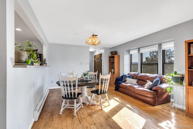 9591 State Highway 96, Westcliffe, CO 81252 - dining space featuring a baseboard heating unit, light wood-style floors, and a chandelier