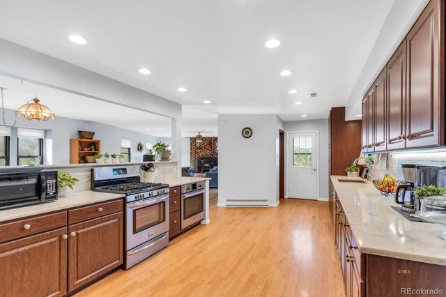 9591 State Highway 96, Westcliffe, CO 81252 - kitchen with stainless steel appliances, a baseboard heating unit, light wood-type flooring, recessed lighting, and light stone countertops