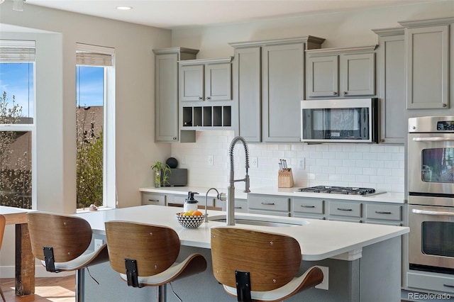 4464 E 139th Ave, Thornton, CO 80602 - kitchen featuring gray cabinetry, appliances with stainless steel finishes, a sink, backsplash, and recessed lighting