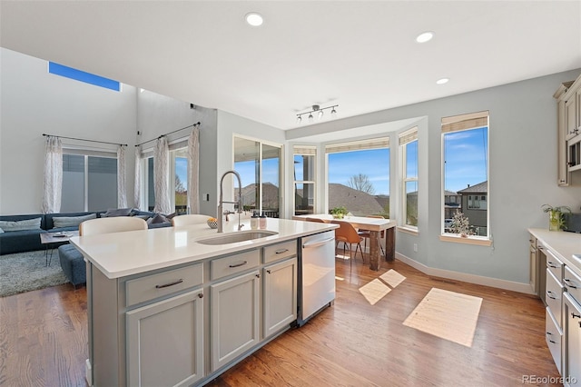 4464 E 139th Ave, Thornton, CO 80602 - kitchen featuring a sink, stainless steel dishwasher, gray cabinetry, light countertops, and light wood-style floors