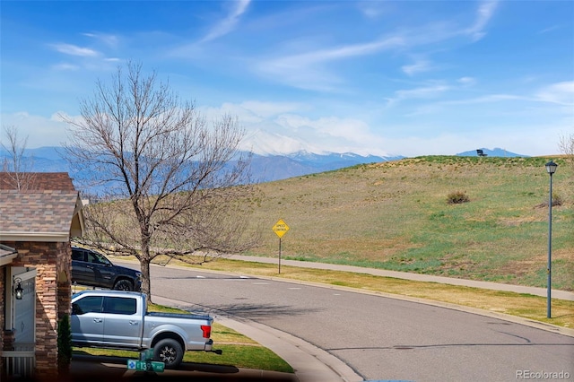 4464 E 139th Ave, Thornton, CO 80602 - view of asphalt street with a mountain view, traffic signs, curbs, street lights, and sidewalks