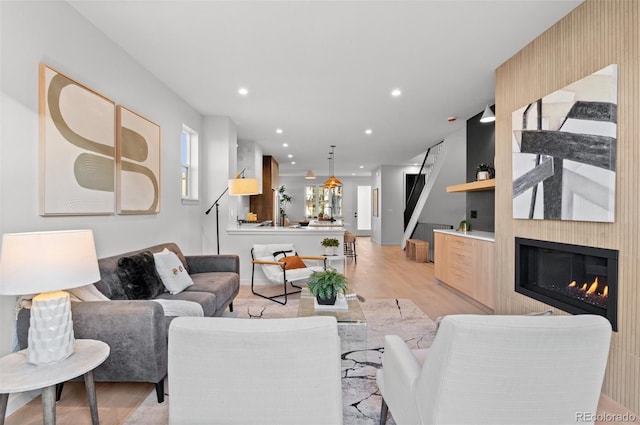 living room with a large fireplace and light wood-type flooring