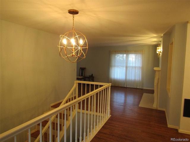 hall with dark wood-type flooring and a chandelier