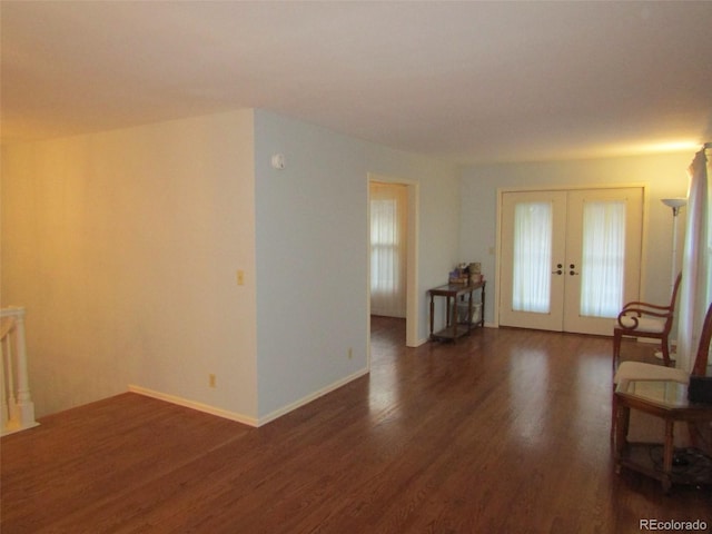 unfurnished living room with dark hardwood / wood-style flooring and french doors