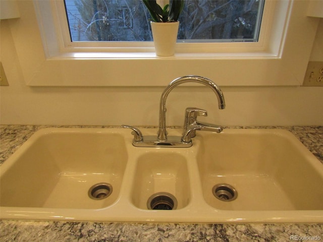 room details featuring light stone counters and sink