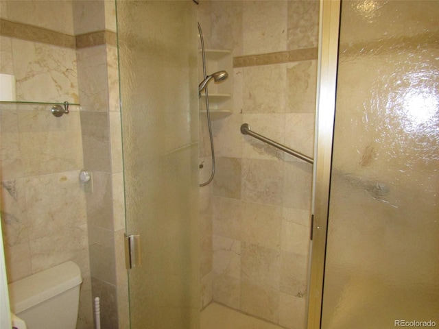 bathroom with toilet and a shower with shower door