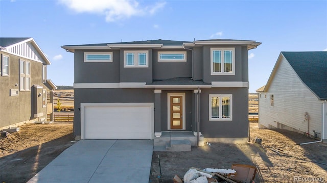 view of front of home with driveway, an attached garage, and stucco siding