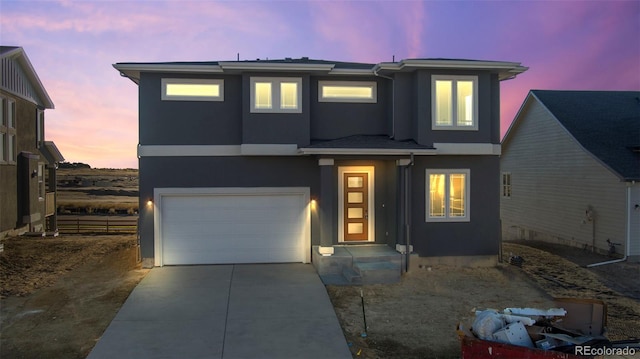 view of front of home with driveway, an attached garage, and stucco siding